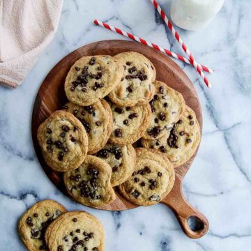 small batch chocolate chip cookies piled onto cutting board.