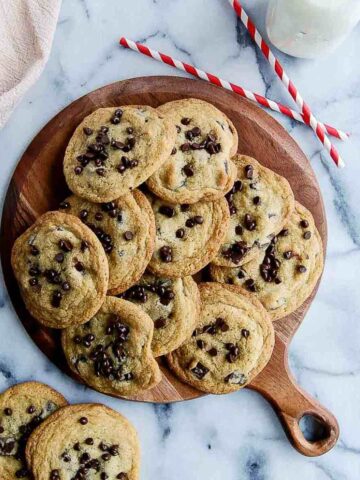 small batch chocolate chip cookies piled onto cutting board.