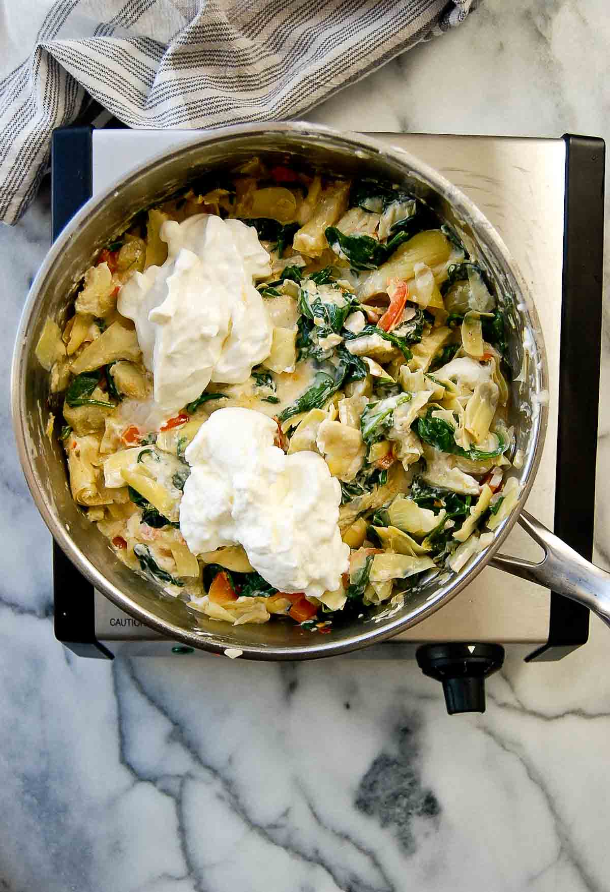 spinach and artichoke dip with sour cream and greek yogurt added to pan.
