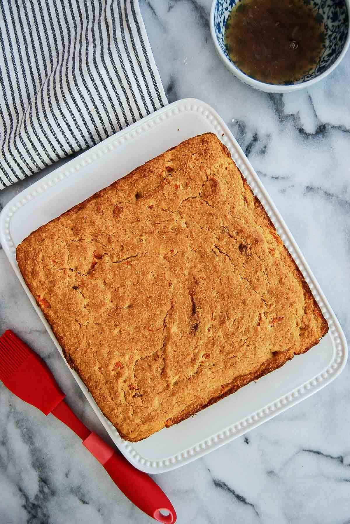 baked sweet potato corn bread on serving plate with maple sauce to the side.