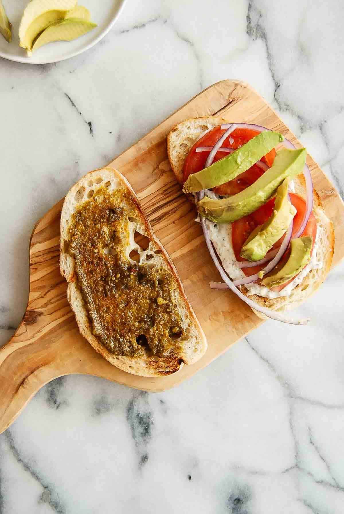 tunacado sandwich assembly on cutting board.