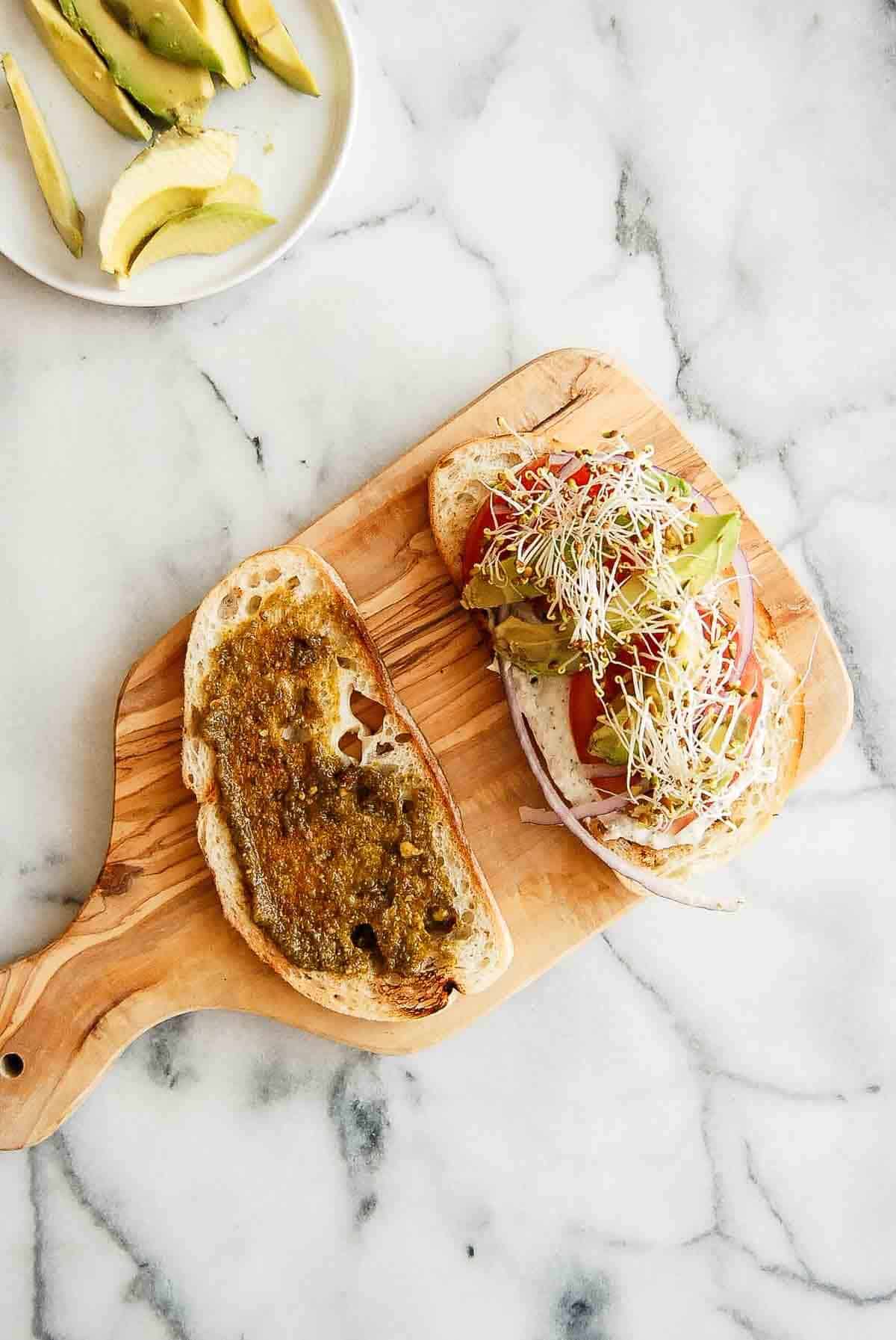 tunacado sandwich assembly on cutting board.