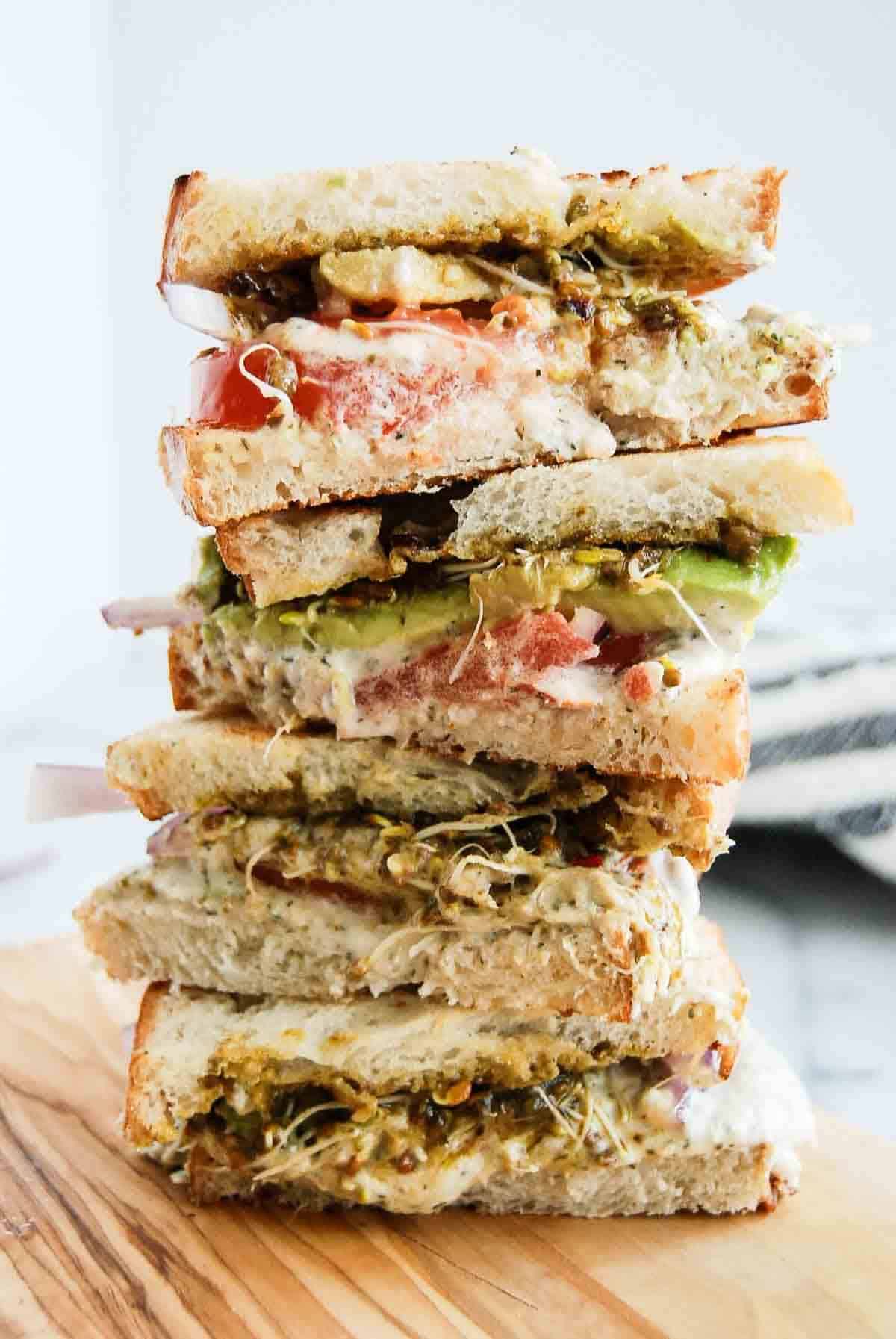 stacked tunacado sandwiches on cutting board.