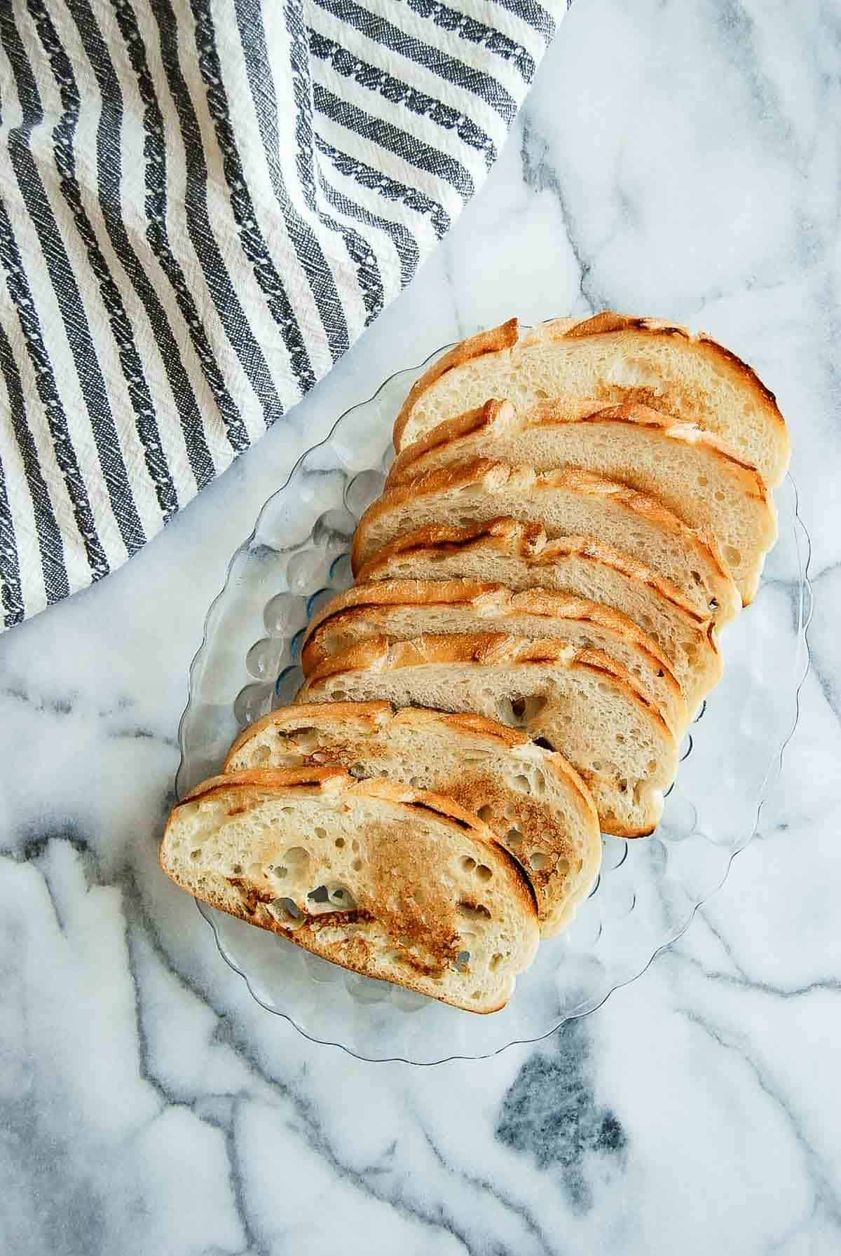 plate of grilled sourdough bread on countertop.