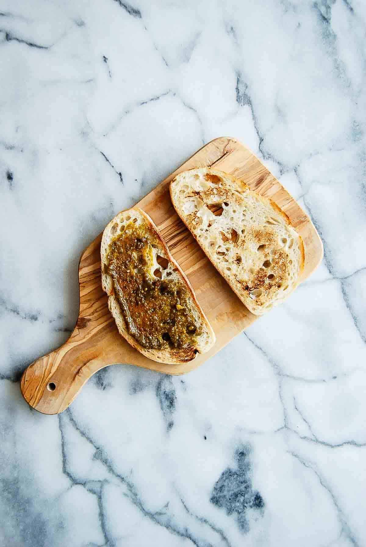 sourdough bread with one side spread with spicy pesto.