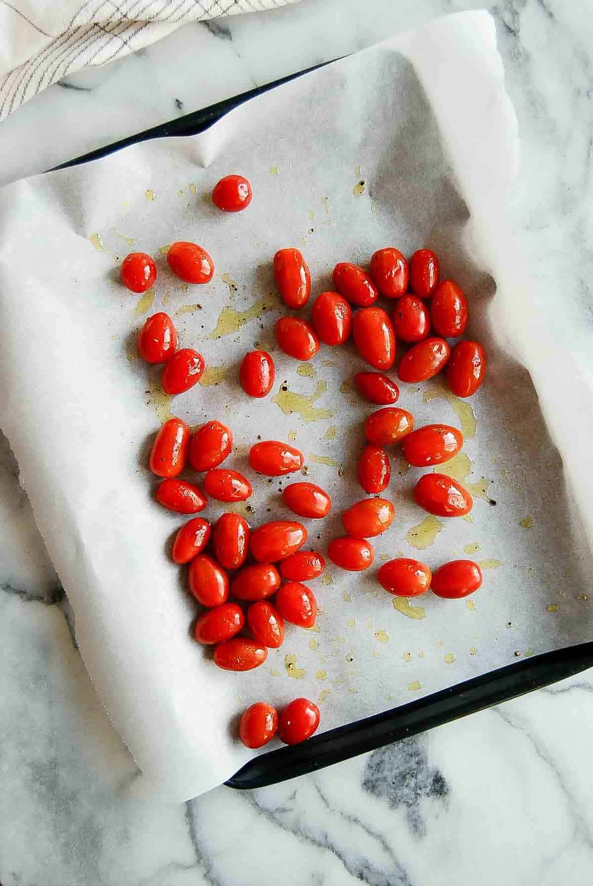 tomatoes ready for roasting on sheet pan.