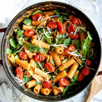 pasta with chickpeas (pasta e ceci) in pot, with tomatoes, and spinach.