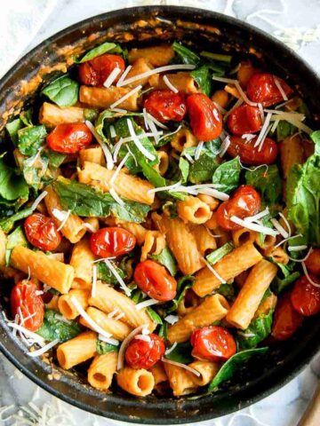pasta with chickpeas (pasta e ceci) in pot, with tomatoes, and spinach.