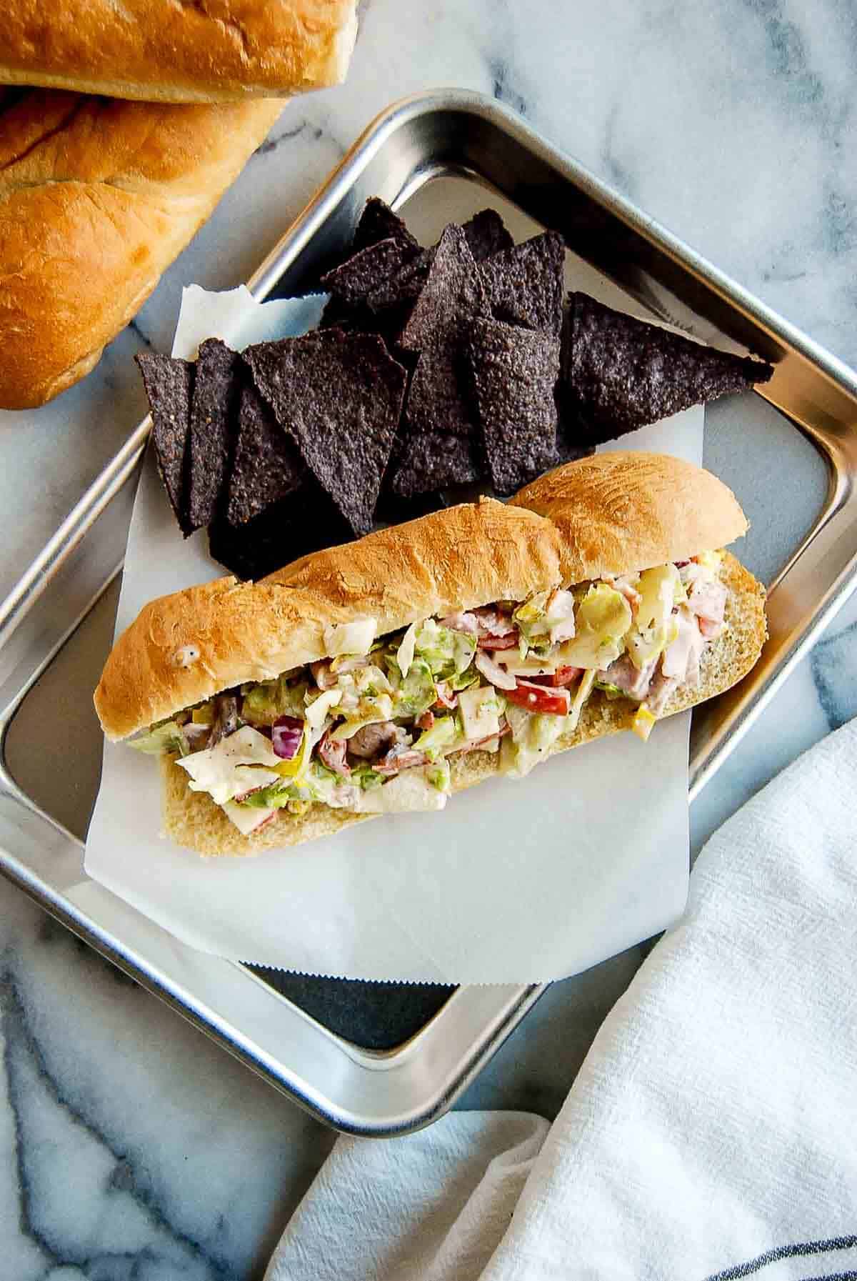 chopped italian sandwiche on tray with chips.