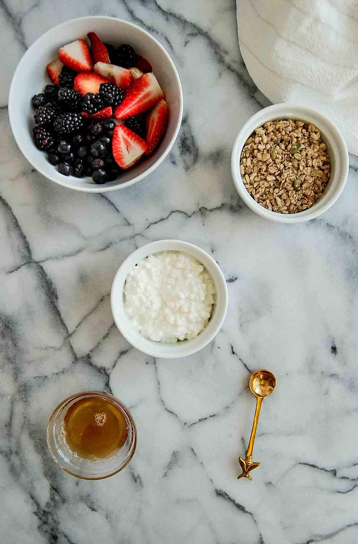 ingredients for cottage cheese with fruit bowls, ready to assemble on countertop.