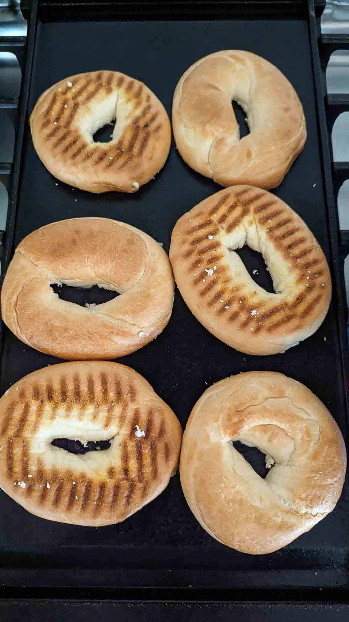 bagels toasting on cooktop.