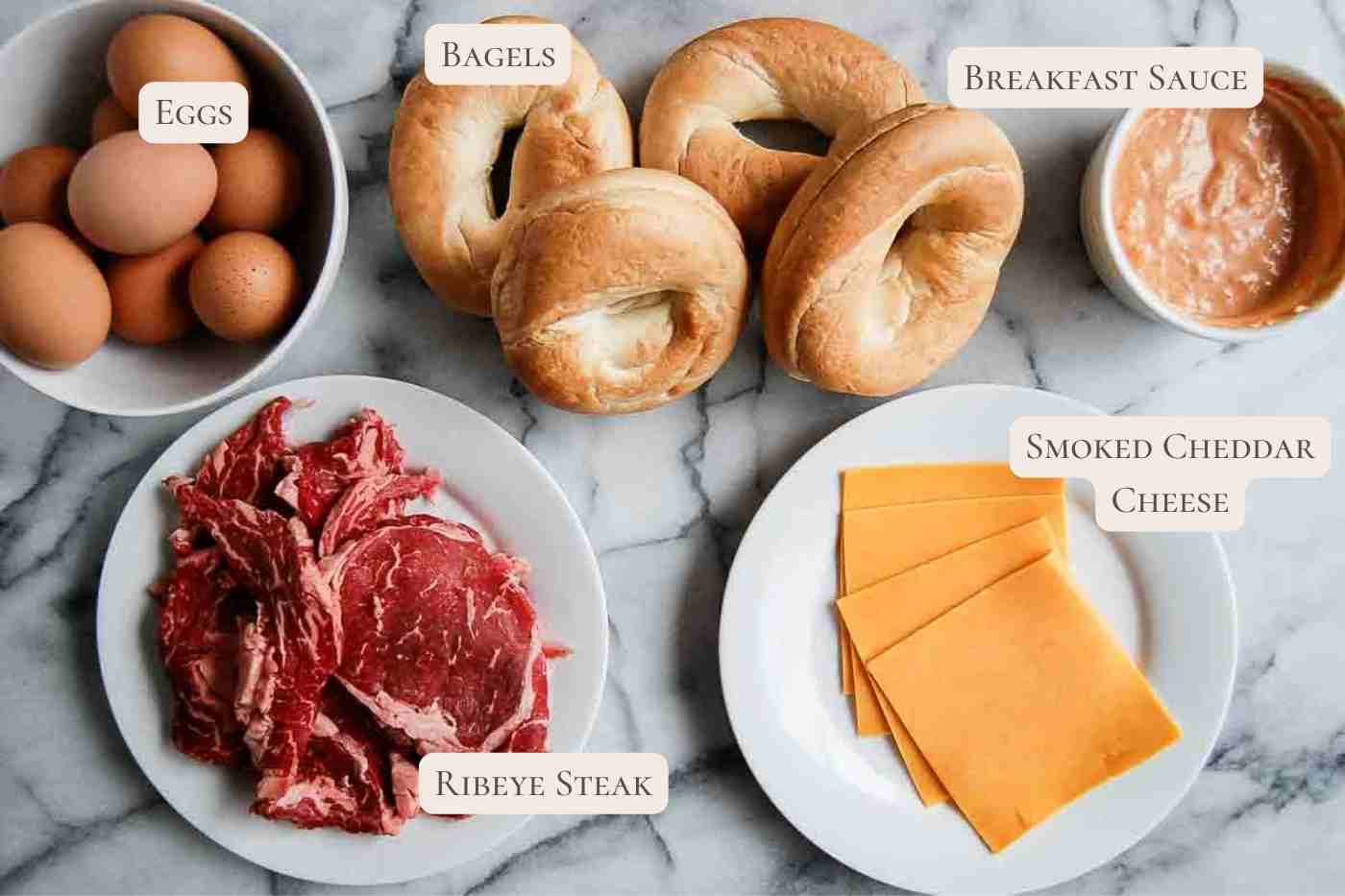 ingredients for steak egg and cheese bagels on countertop.