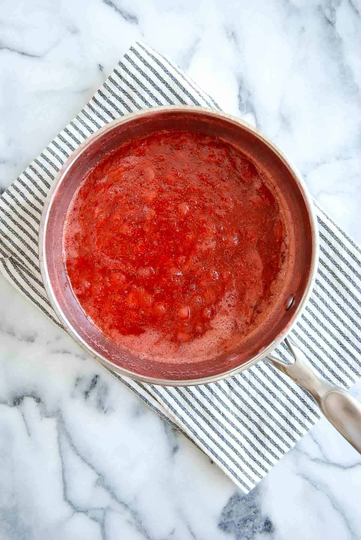 Reduced strawberry puree in saucepan.