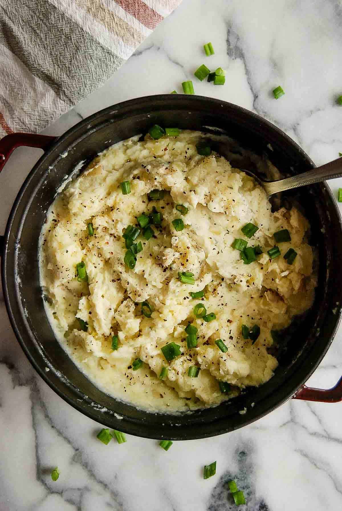 cheesy boursin mashed potatoes in pot with serving spoot.