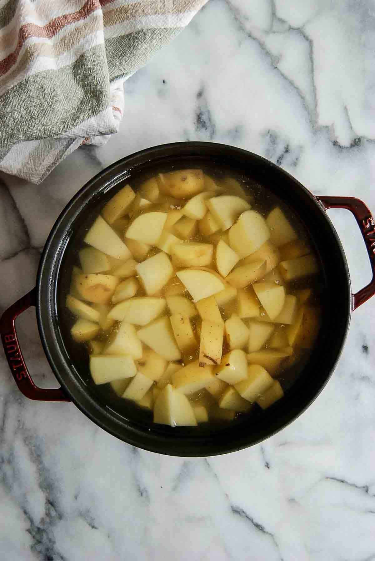 diced yukon gold potatoes in pot with water, ready for boiling.