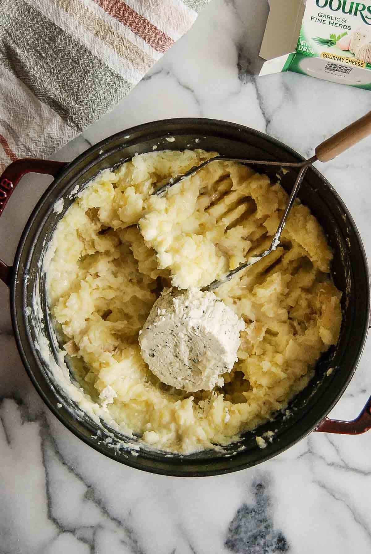 mashed potatoes in pot with Boursin cheese.