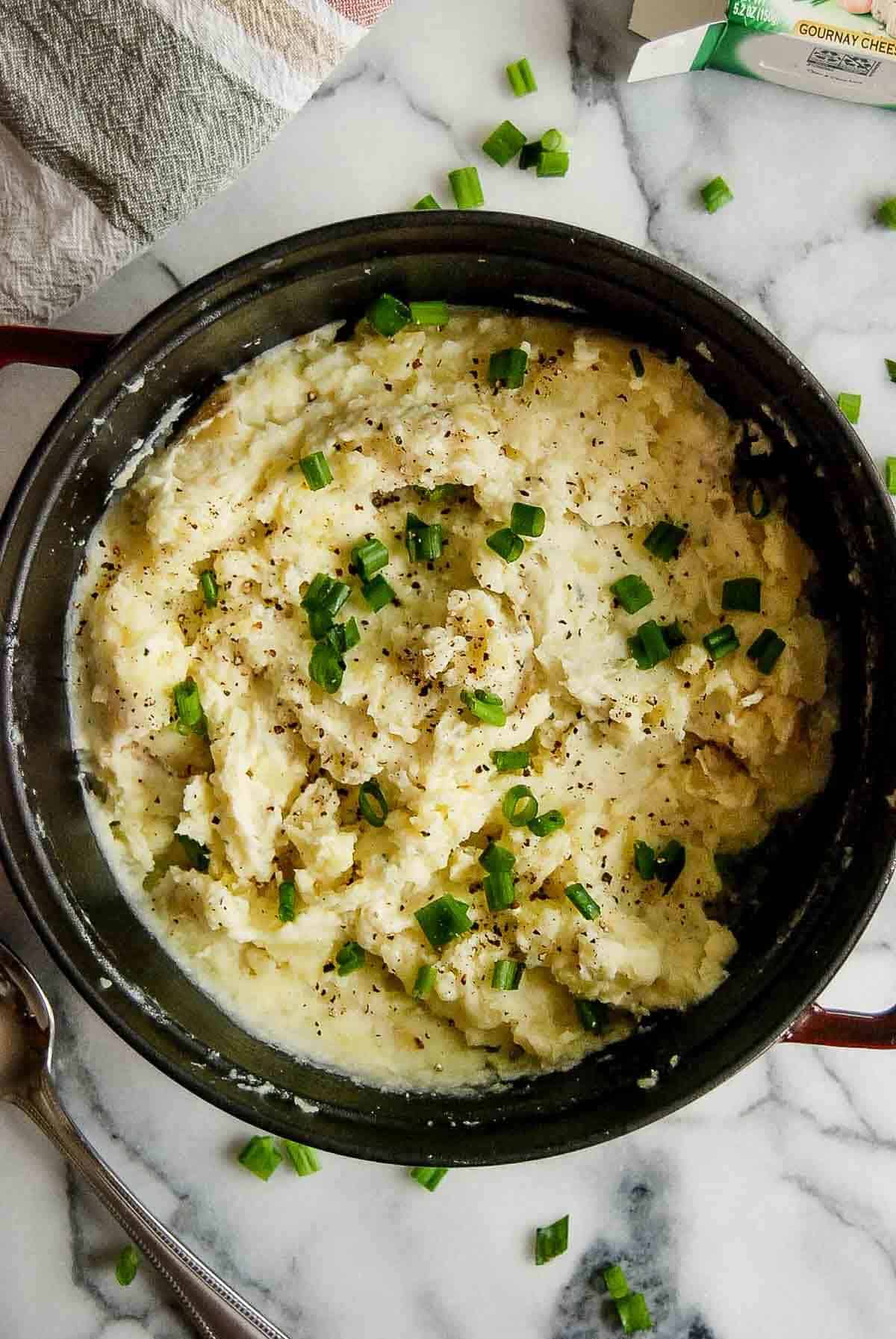 closeup of boursin mashed potatoes in pot on counterop.