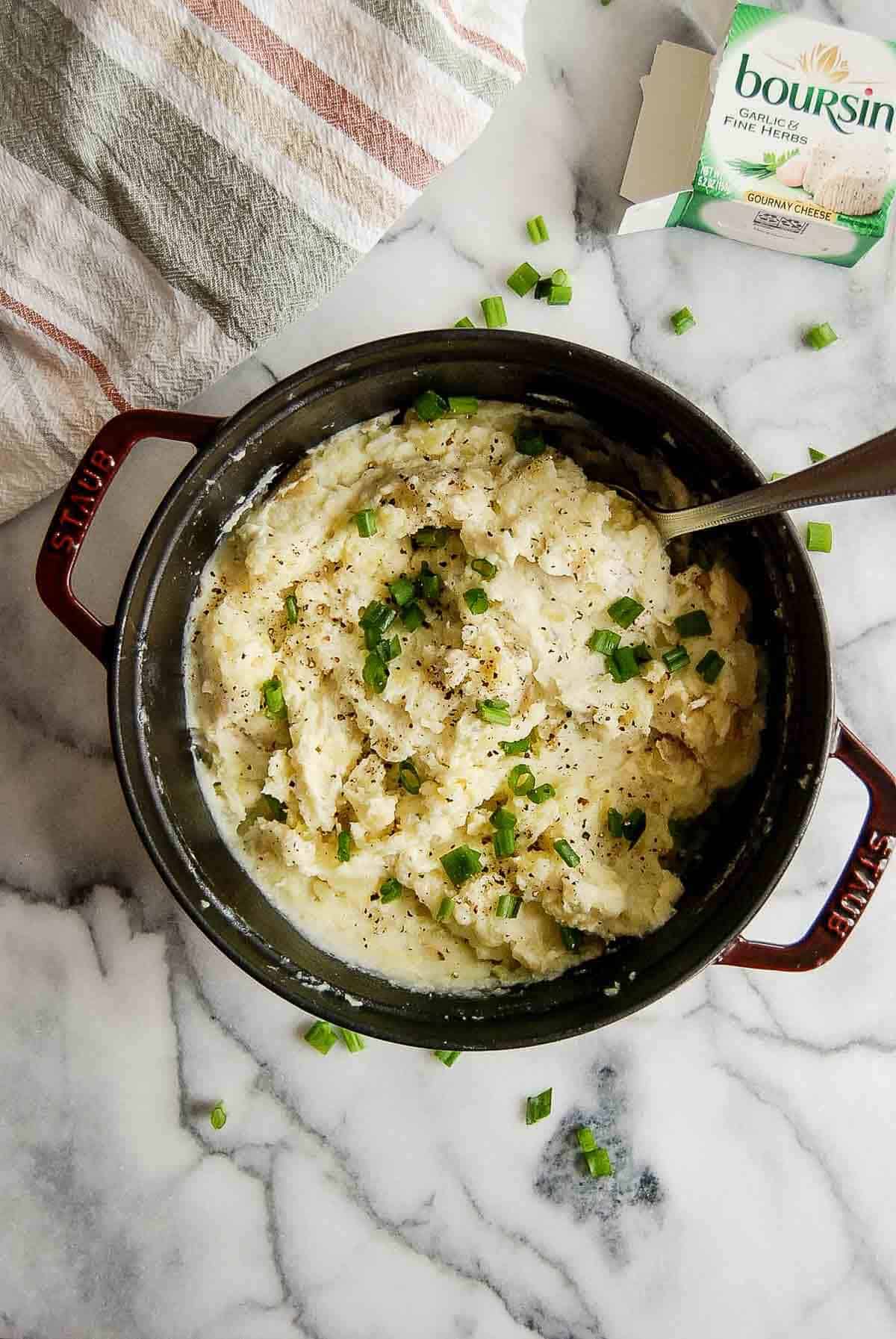 boursin mashed potatoes in pot with serving spoon on the side.