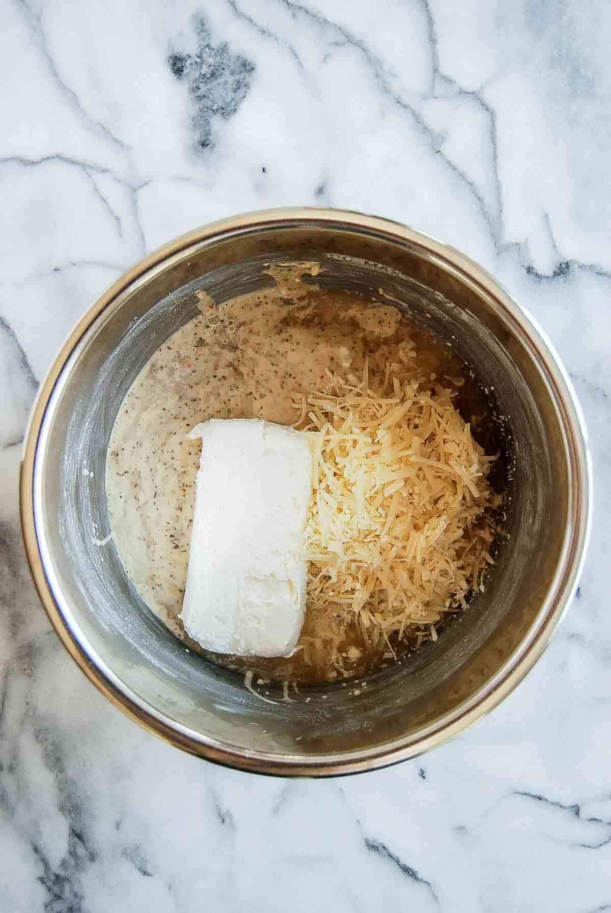 chicken in crockpot with garlic parmesan sauce, cream cheese and parmesan cheese.