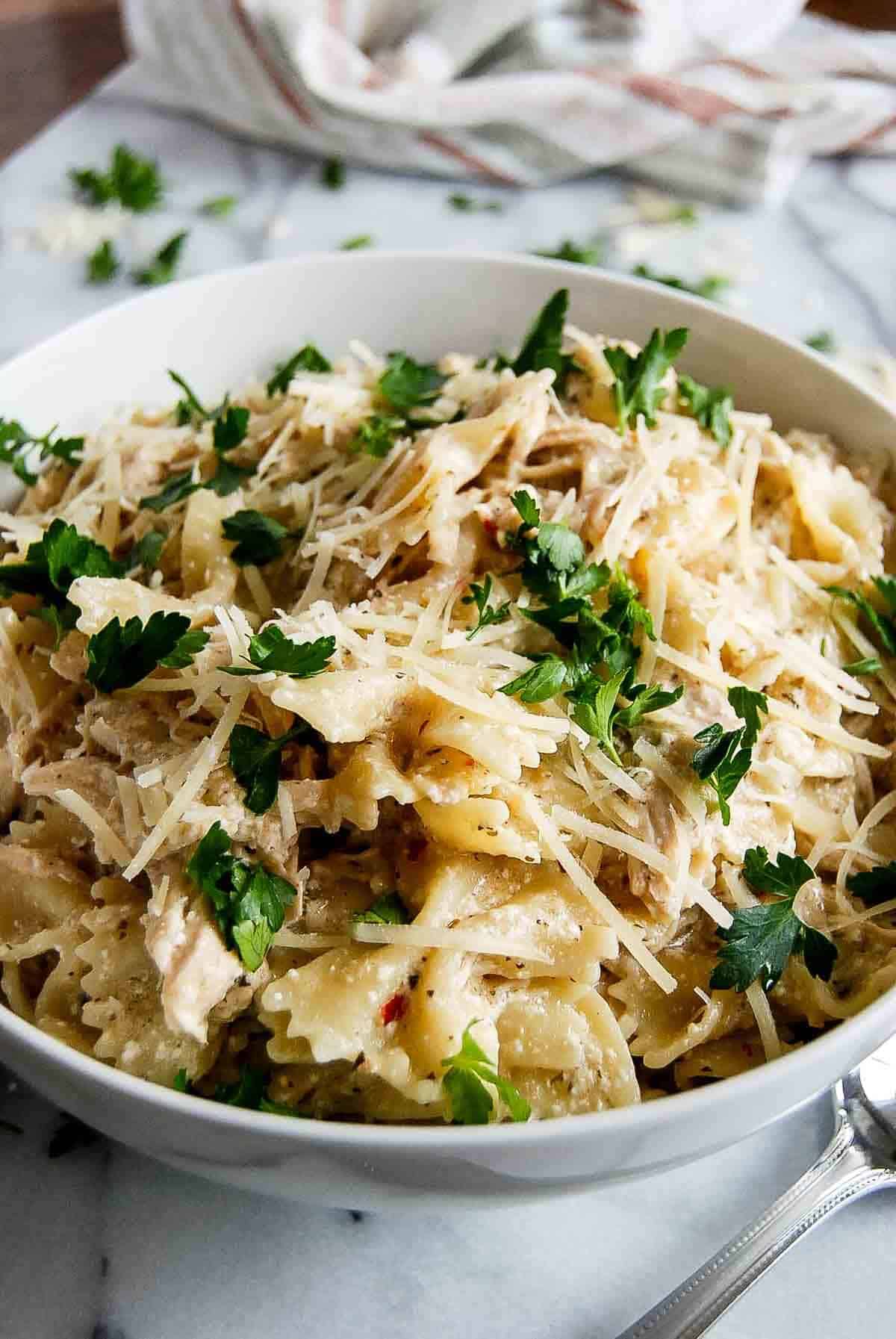 side view of garlic parmesan chicken pasta in serving bowel on countertop.