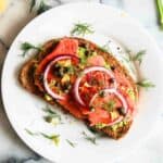 smoked salmon toast with avocado on plate.