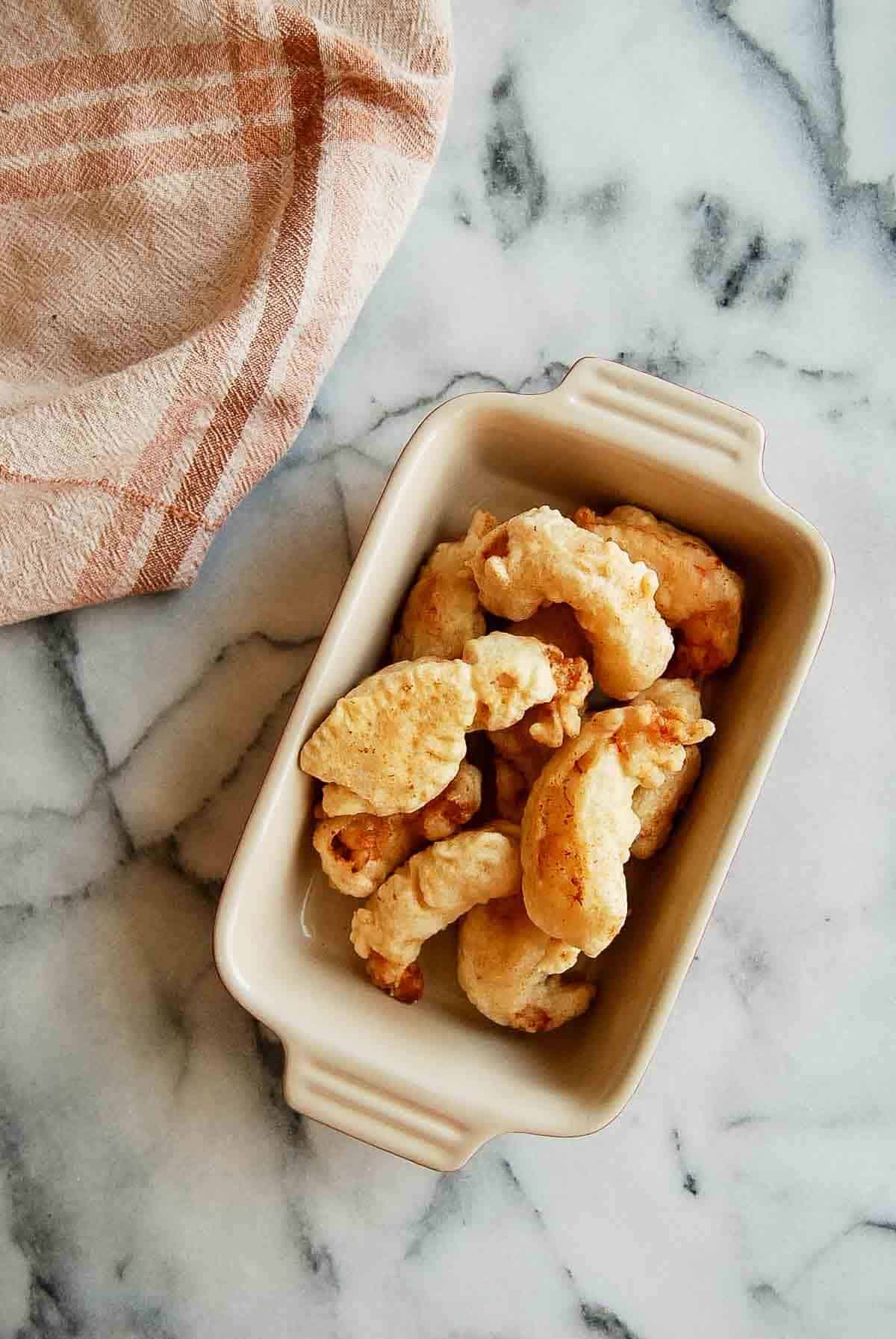 shrimp tempura in serving dish on counter.