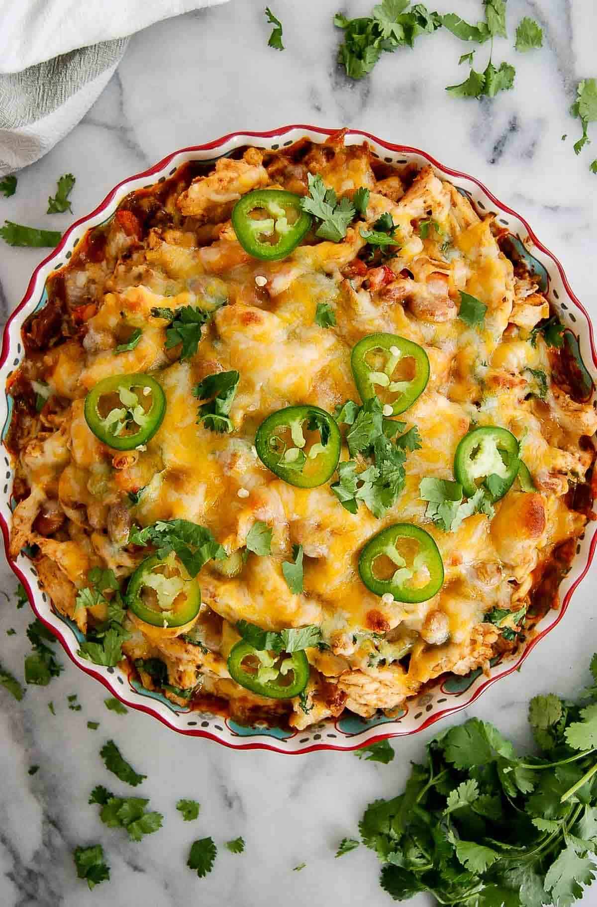 baked chicken tamale pie with cilantro and jalapeno slices on top.