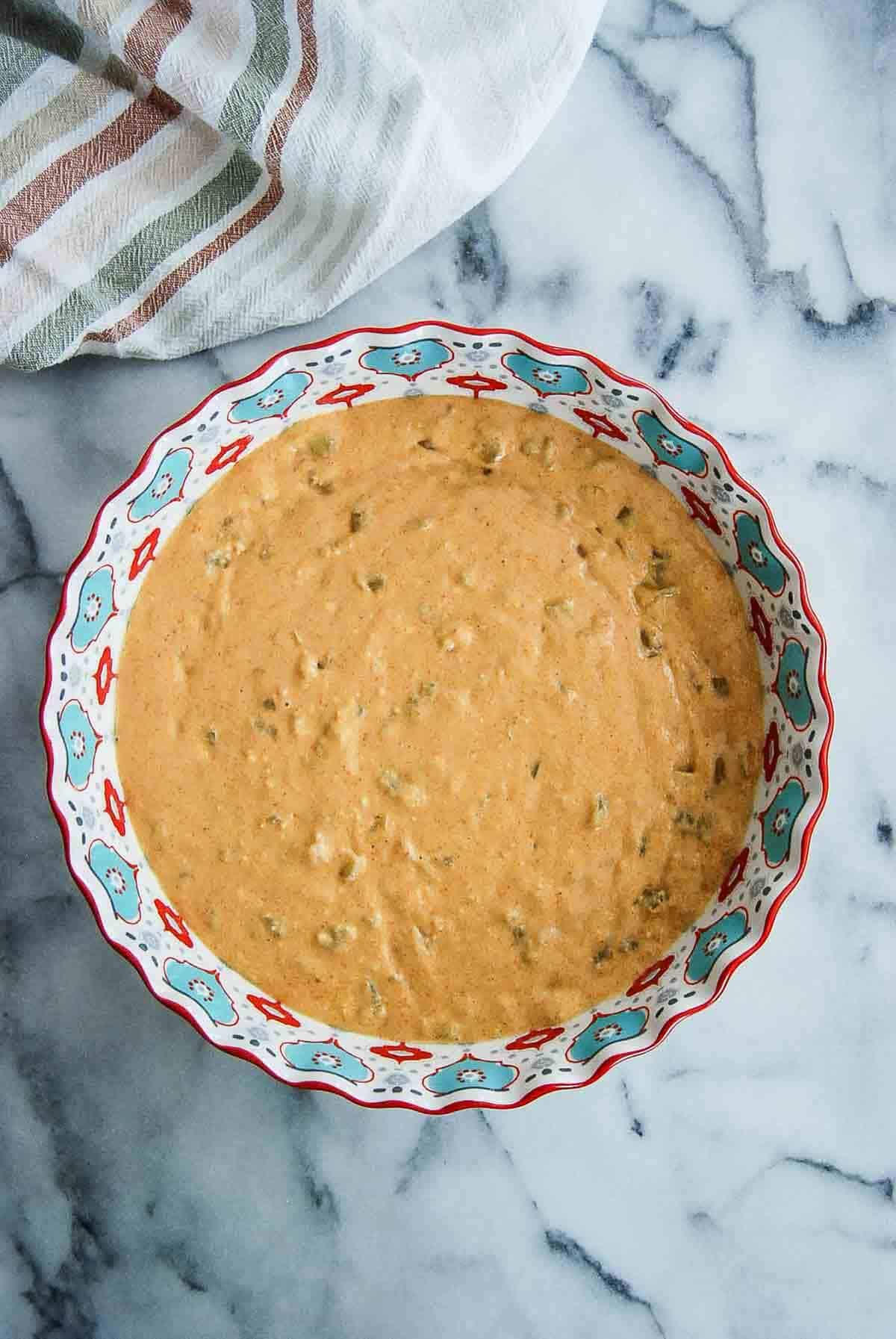 cornbread mix with green hatch chiles in pie plate.