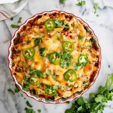 baked chicken tamale pie with cilantro and jalapeno slices on top.