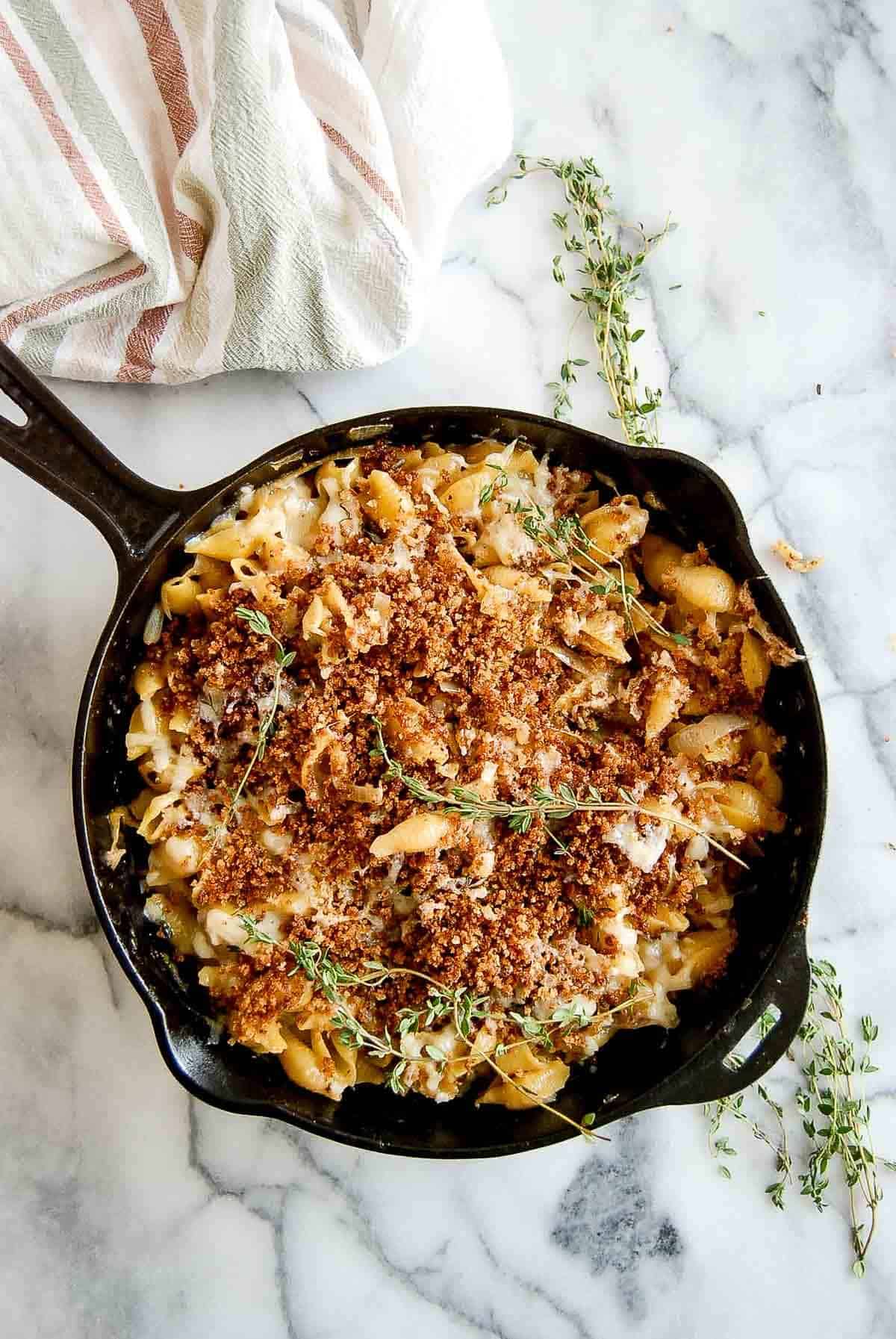 skillet of french onion soup pasta with toasted breadcrumbs on top.