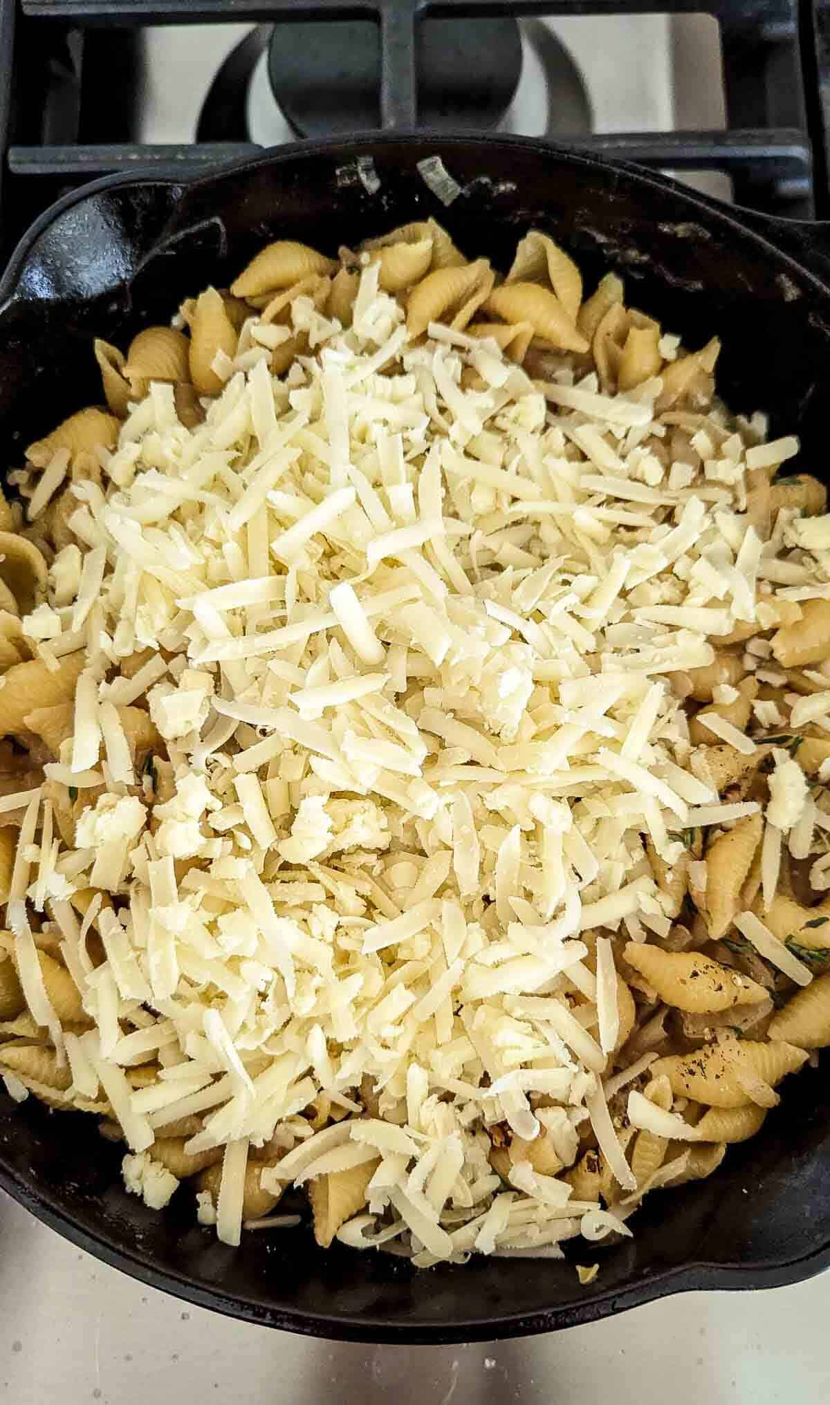 french onion pasta in pot with gruyere cheese on top.