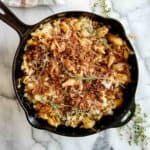 skillet of french onion soup pasta with toasted breadcrumbs and thyme on top.