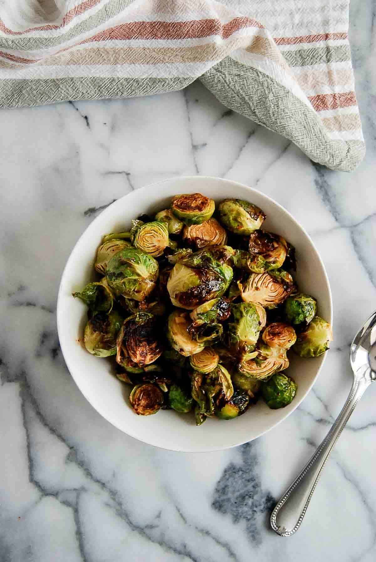 honey sriracha brussels sprouts in bowl on countertop.