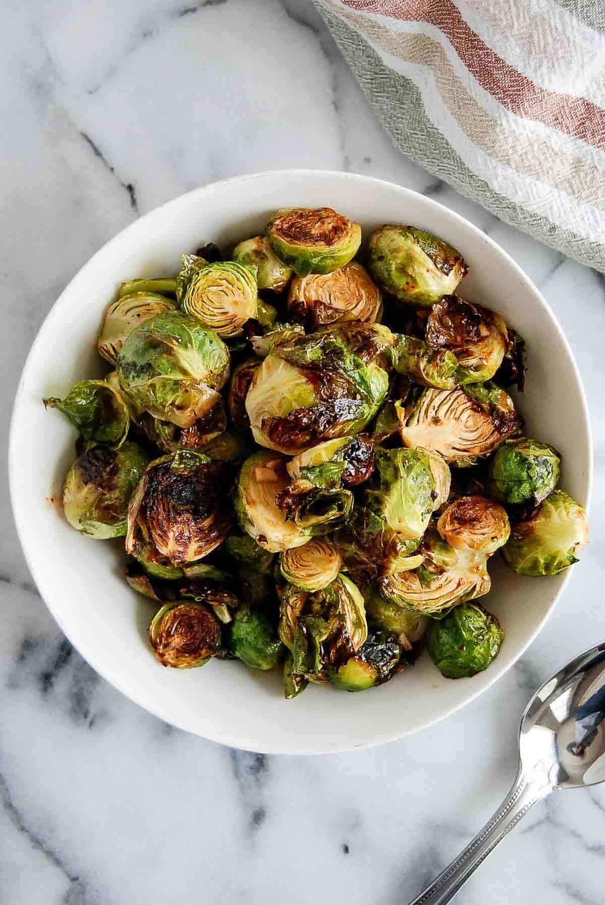 honey sriracha brussels sprouts in bowl on countertop.