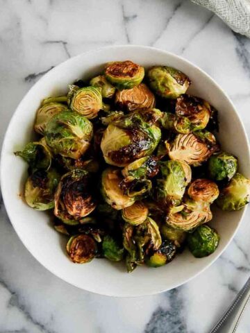 honey sriracha brussels sprouts in bowl on countertop.