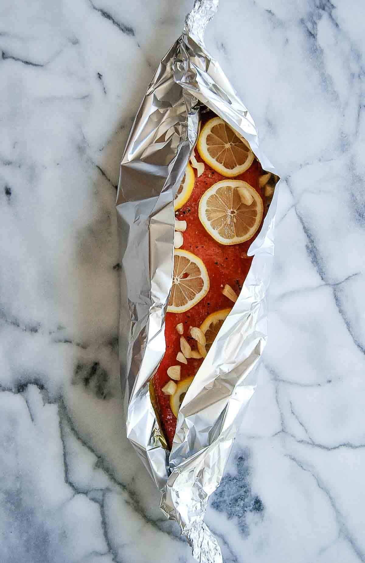 wrapping salmon in foil with lemon and dill inside.