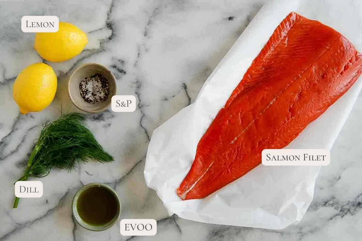 ingredients for baked salmon in foil with lemon and dill on countertop.