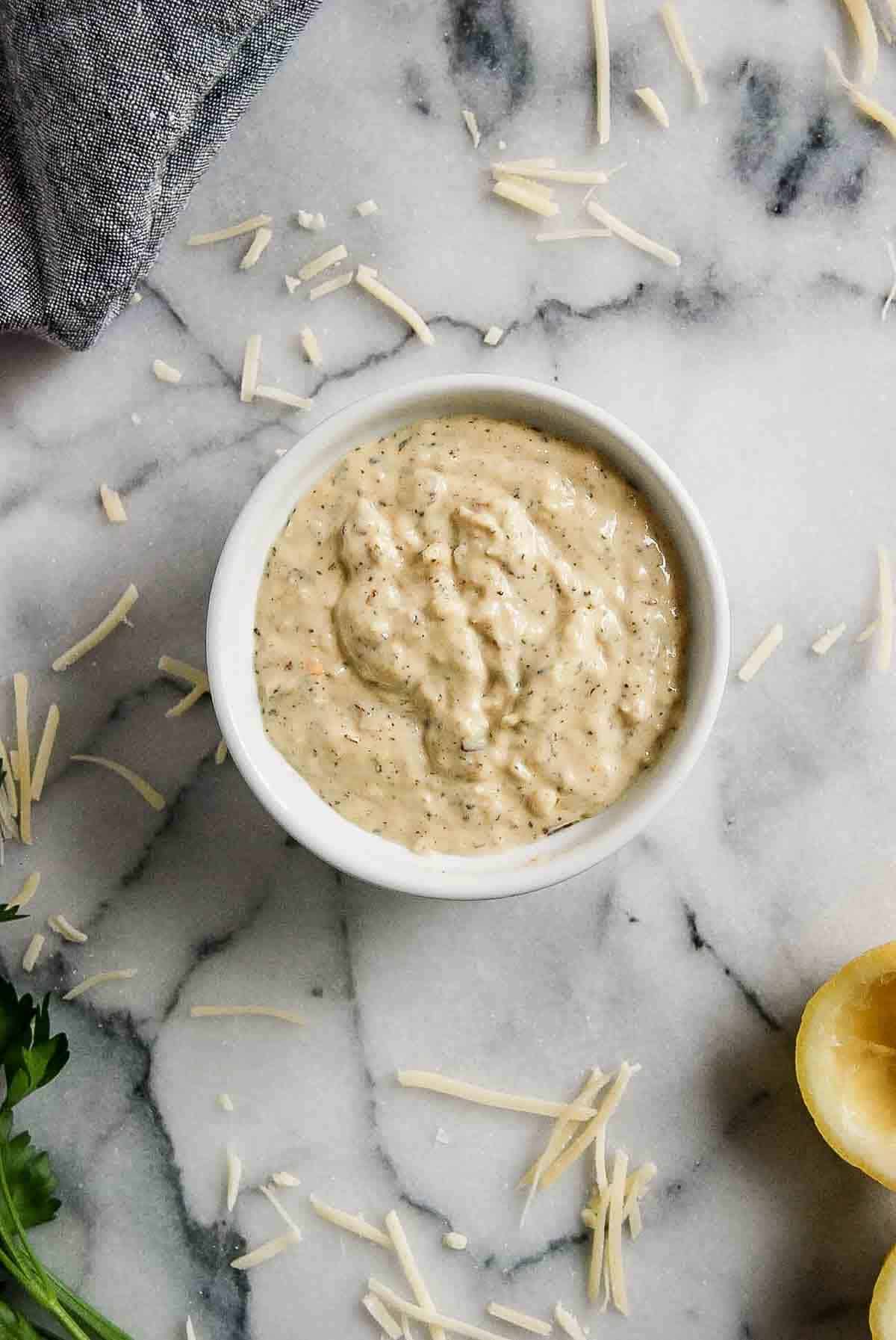 bowl of garlic parmesan sauce on countertop.
