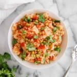 instant pot mexican rice in bowl on countertop with cilantro on the side.