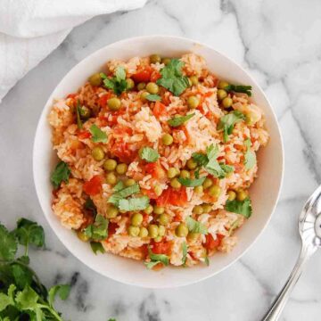 instant pot mexican rice in bowl on countertop with cilantro on the side.