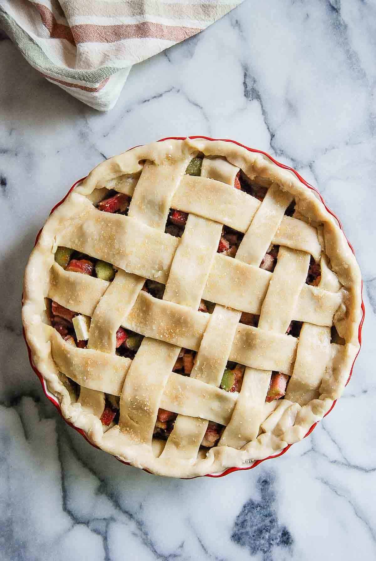 pre-baked rhubarb pie with lattice crust with egg wash and turbinado sugar on top.
