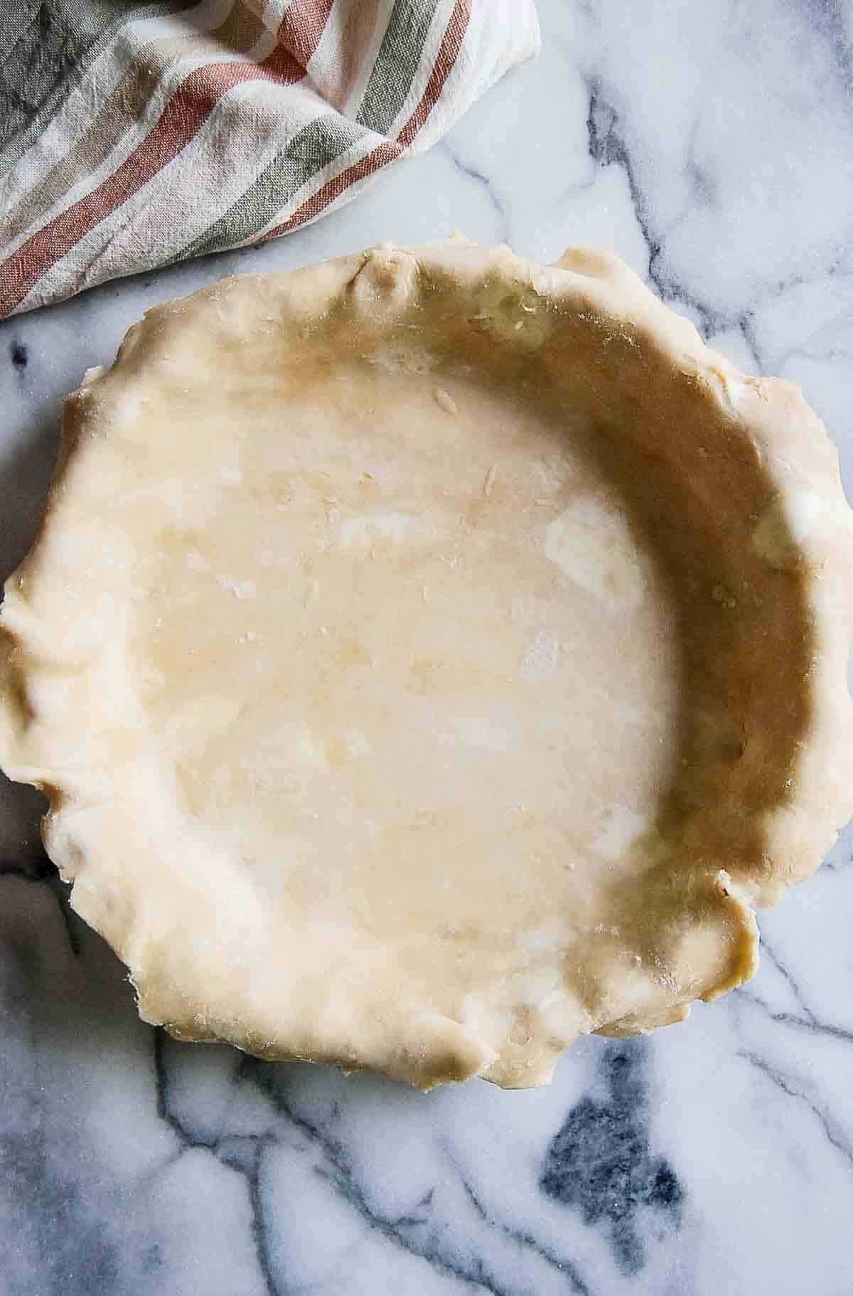 rolled out pie dough in pie plate.