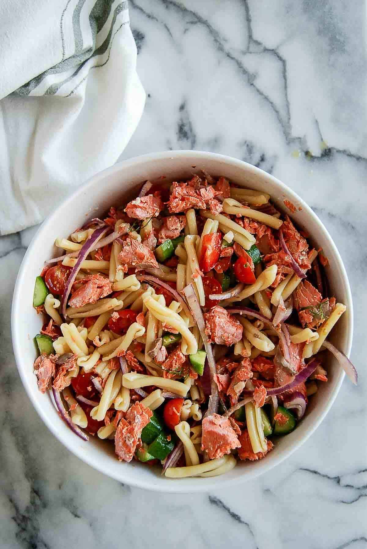 salmon pasta salad in bowl on countertop.