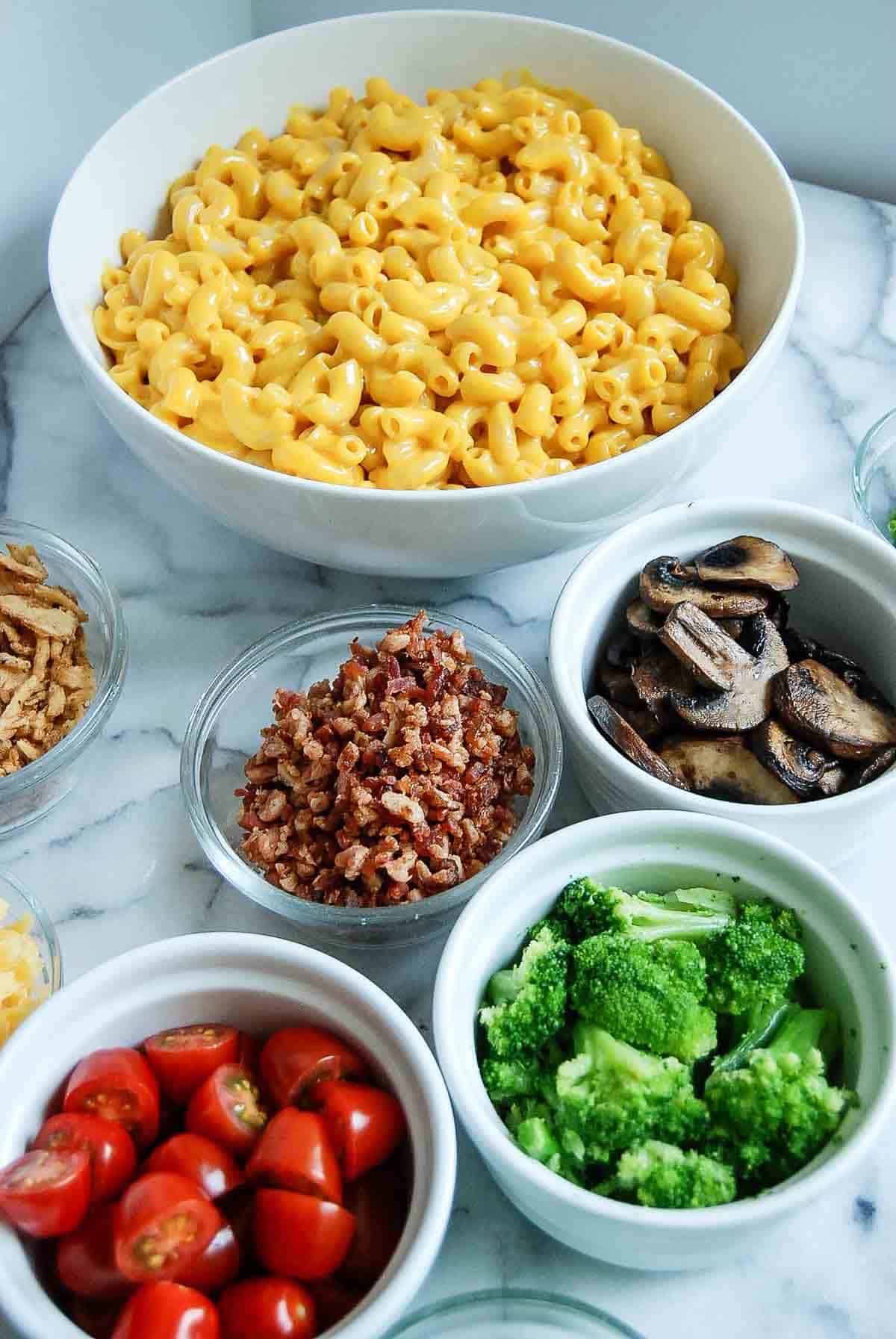mac and cheese bar with toppings on countertop.