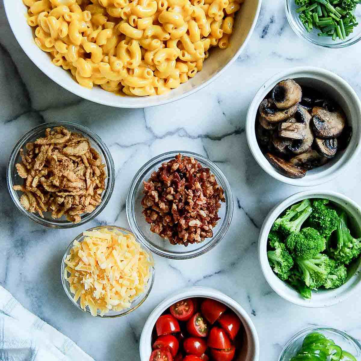 mac and cheese bar with toppings on countertop.