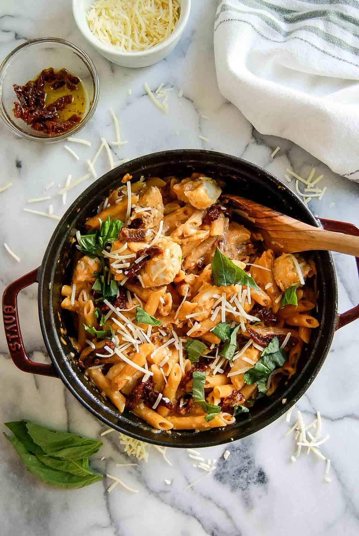 marry me chicken pasta in pot with wooden spoon.