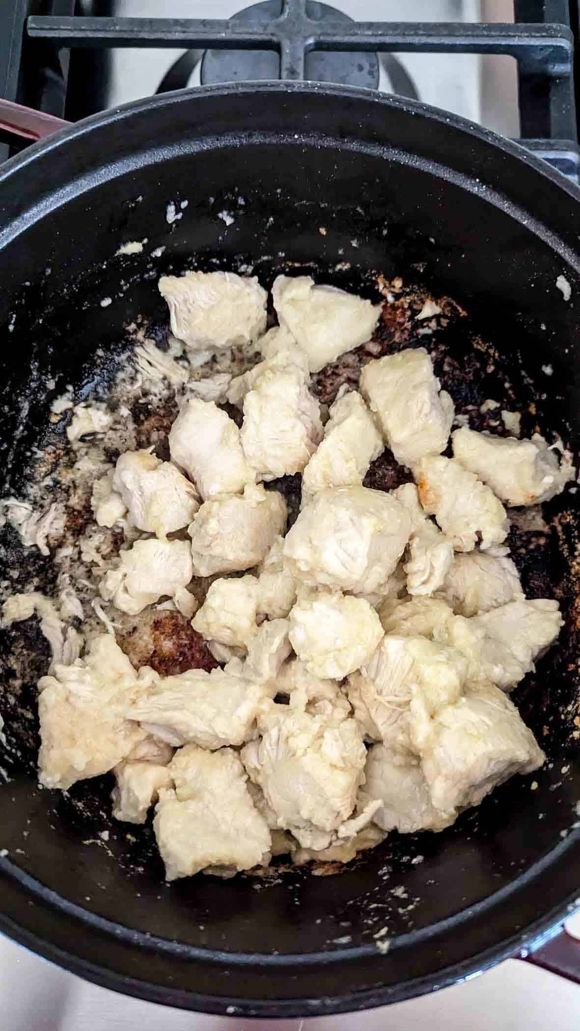 chicken pieces sautéing in pot.