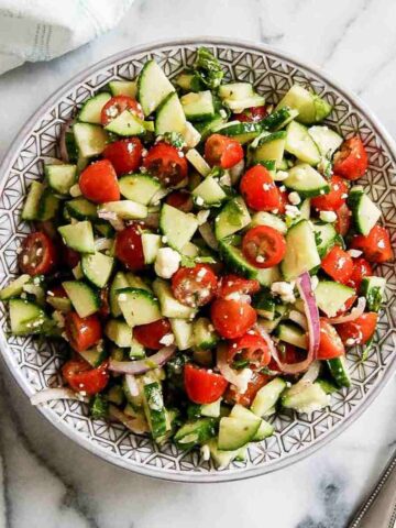 mediterranean cucumber salad in serving bowl on countertop.
