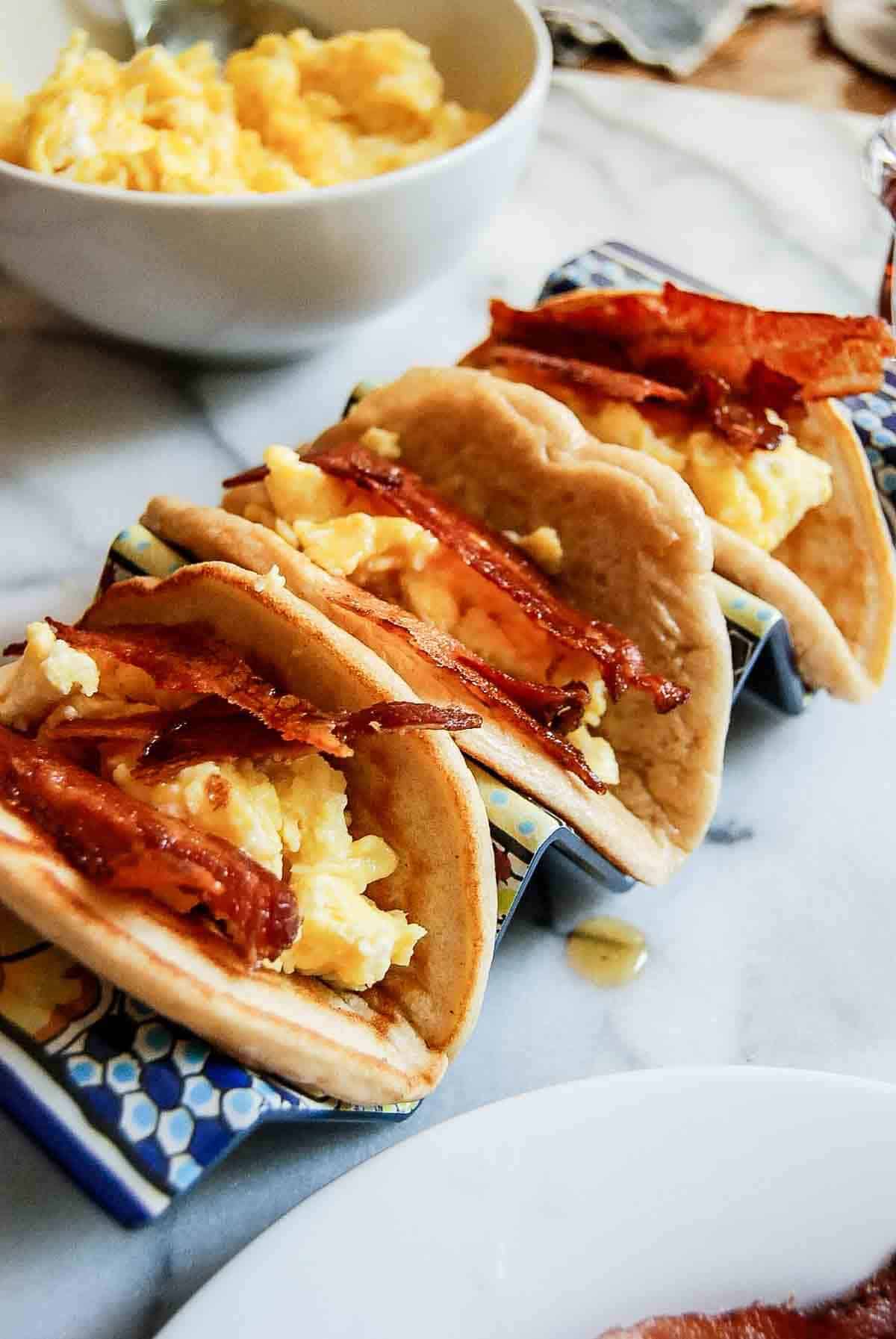 side view of savory pancake tacos with bacon and eggs.