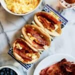 closeup of pancake tacos with bacon and eggs on the countertop.